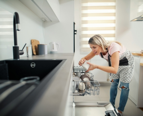 a-tidy-woman-putting-dishes-into-a-dishwasher